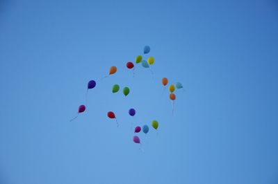 Low angle view of balloons against blue sky