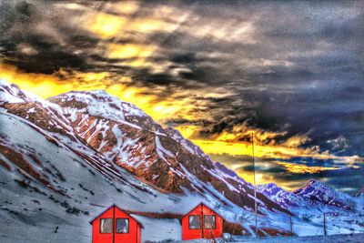 Scenic view of mountains against cloudy sky during sunset