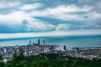 High angle view of city by sea against sky