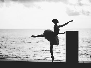 Woman ballet dancing against sea