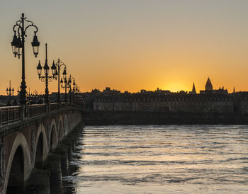 Bridge over river against sky during sunset