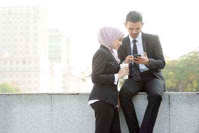 Young man using mobile phone in city
