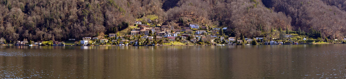 Panoramic view of lake and buildings against trees