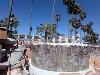 View of palm trees and building against blue sky