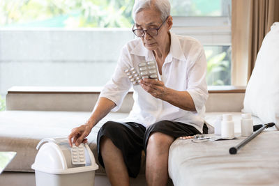 Midsection of man sitting on sofa