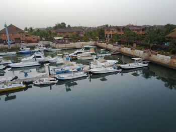 Boats moored at harbor against clear sky