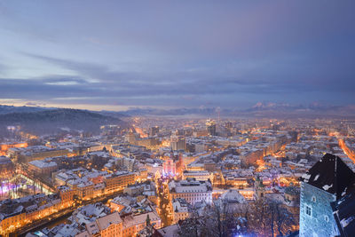 Aerial view of illuminated cityscape against sky