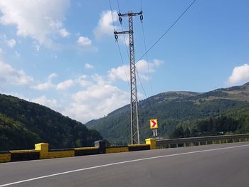 Road by mountain against sky