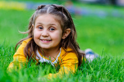 Portrait of smiling girl lying on grass