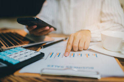 Midsection of businessman working on table