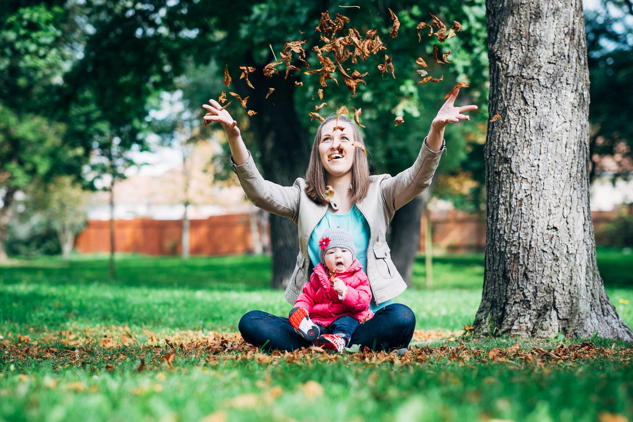 looking at camera, portrait, person, smiling, front view, happiness, childhood, focus on foreground, tree, lifestyles, casual clothing, leisure activity, elementary age, full length, girls, standing, park - man made space, young adult