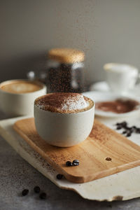 Close-up of coffee cup on cutting board