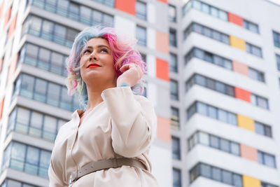 Woman with colorful dyed hair in front of building
