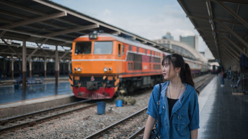 Teenage girl standing at railroad station platform