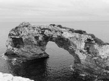 Rock formations by sea against sky