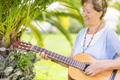 Woman playing guitar outdoors