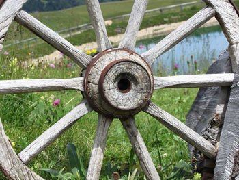 Close-up of abandoned wagon wheel on grassy field