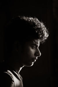 Portrait of young man against black background