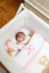 High angle view of baby sleeping in bed