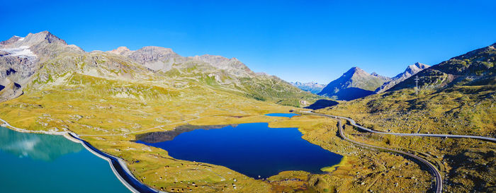 Scenic view of lake and mountains against clear blue sky