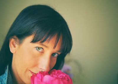 Portrait of woman smelling pink flower