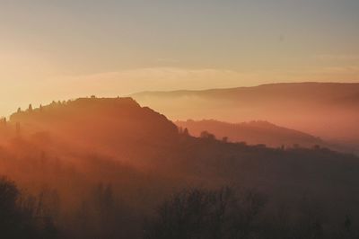 Scenic view of silhouette mountains against sky during sunset
