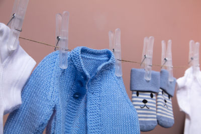 Close-up of clothes hanging on clothesline against wall