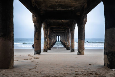 View of pier on beach against sky