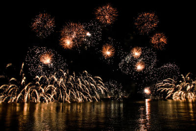 Low angle view of firework display against sky at night