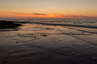 Scenic view of beach against sky during sunset