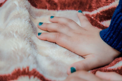 Cropped hand of girl on blanket