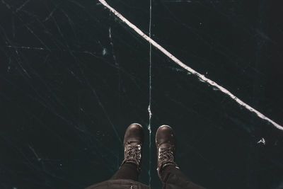 Low section of person standing on frozen lake