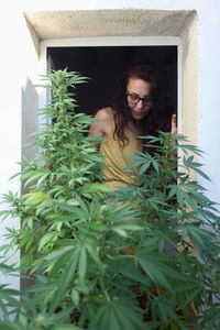 Young woman with plants in foreground