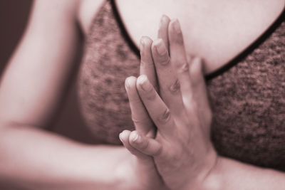 Midsection of woman with hands clasped meditating
