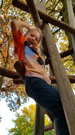 Low angle view of girl playing on tree