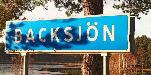 Close-up of road sign against blue sky