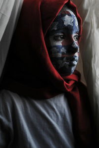 Close-up of thoughtful girl with face paint looking away at home