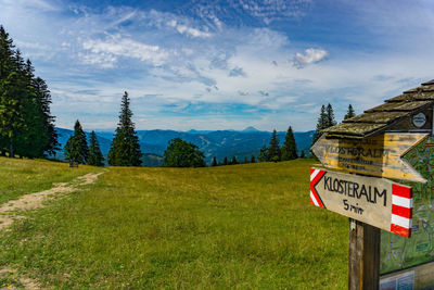 Information sign on landscape against sky