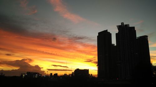 Silhouette buildings against sky during sunset