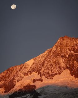 Low angle view of snowcapped mountains against clear sky