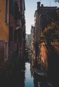 Canal amidst buildings against sky in city