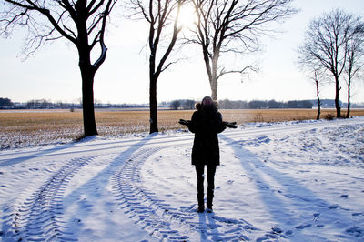 Rear view of man on snow covered field