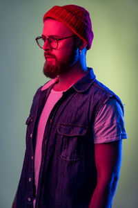 Side view of man standing against gray background