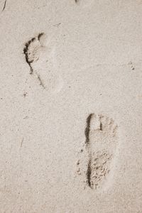 Close-up of footprints on sand at beach