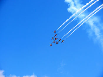 Low angle view of airshow against blue sky