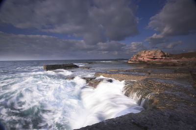 Scenic view of sea against cloudy sky