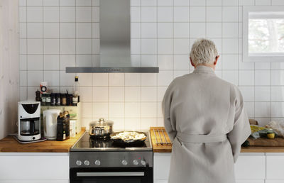 Man in bathrobe preparing food