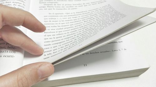 Cropped image of woman writing on book