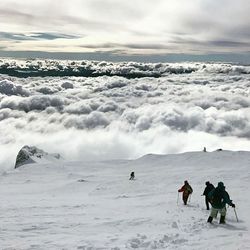 People on snow covered landscape against sky