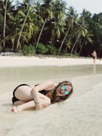 Cheerful young woman enjoying on shore at beach
